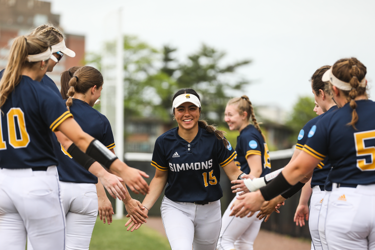 Members of the Simmons softball team congratulating each other after a game