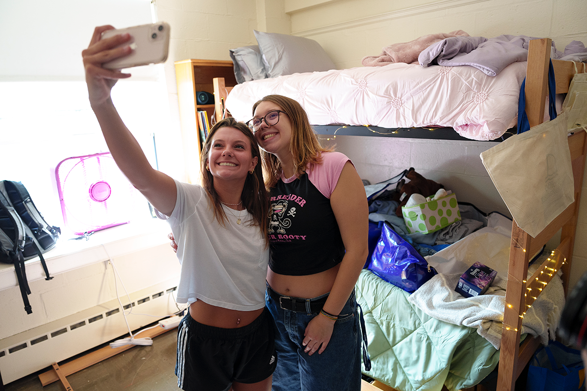 Two Simmons students taking a selfie in their room on move-in day