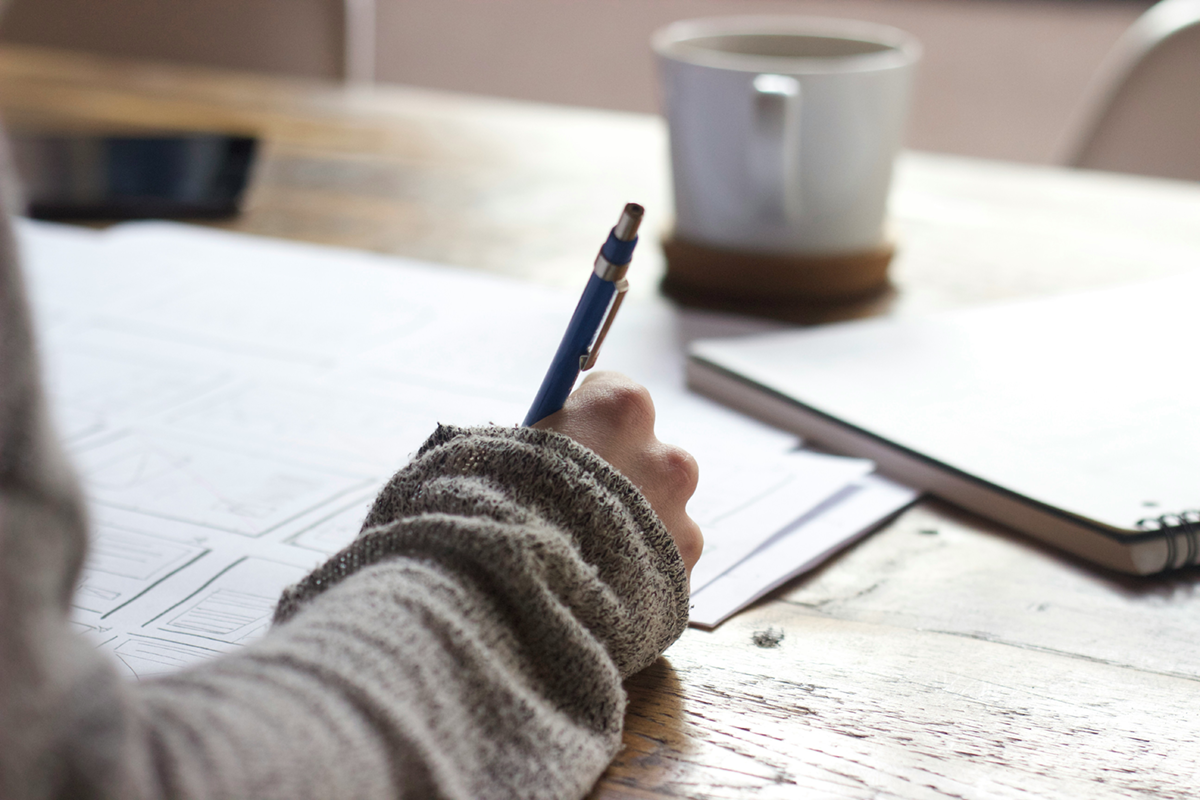 Close-up photo of a student writing with a pen