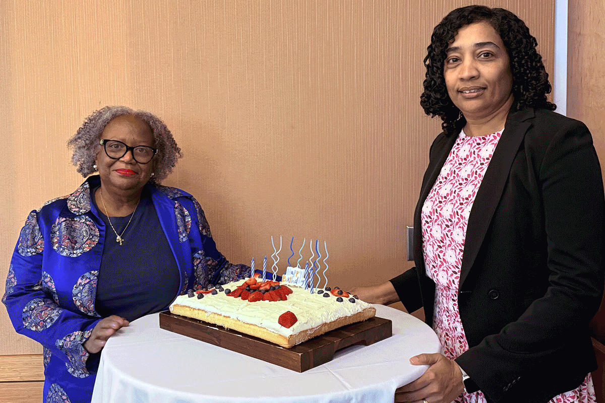 Karen Young-Thomas '77 and Dean Ammina Kothari celebrate Gwen Ifill's birthday with a cake.