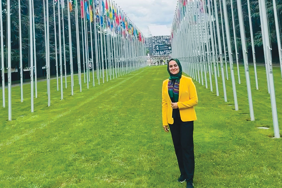 Zalaikha Wahid ’27 standing among flags of nations in Geneva