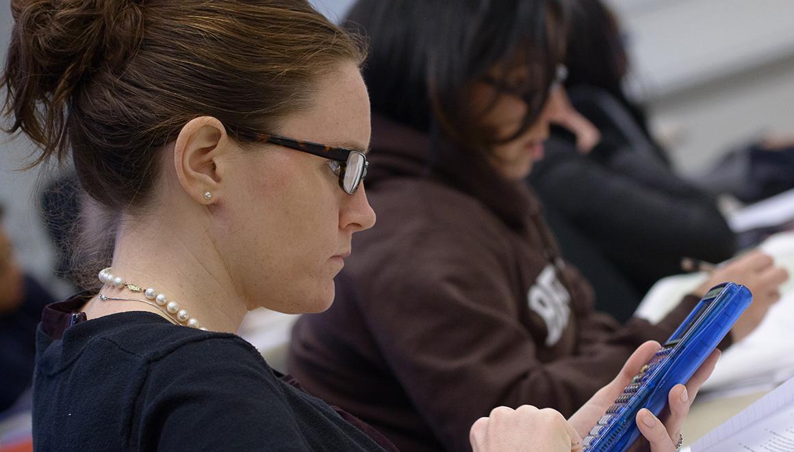 Student working with a calculator in class