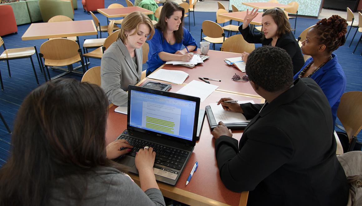 Students sitting around a table in discussion.