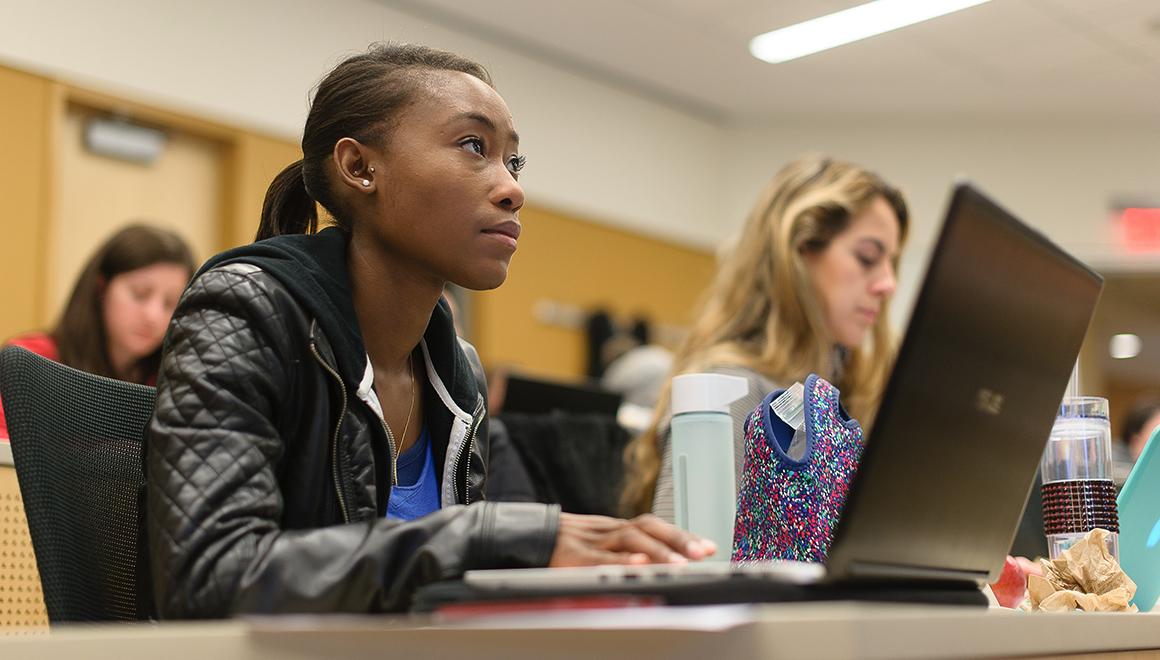 Student in classroom sitting at laptop