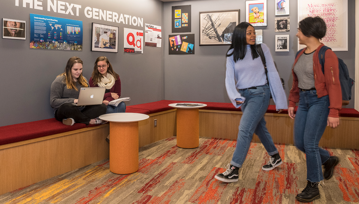 Simmons students working in and walking through the Ifill School lobby