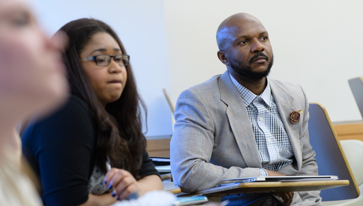 Two graduate students paying attention during a class