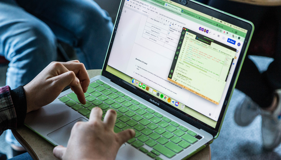 A close-up photo of a Simmons student using their laptop in their lap