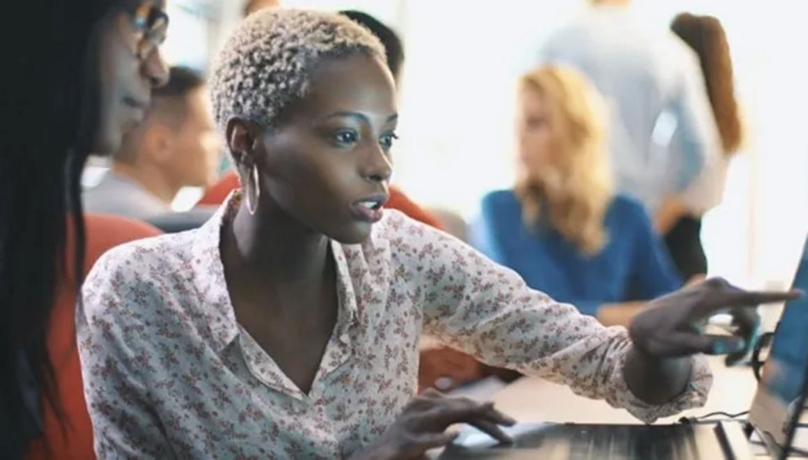 Two students looking intently at a laptop screen