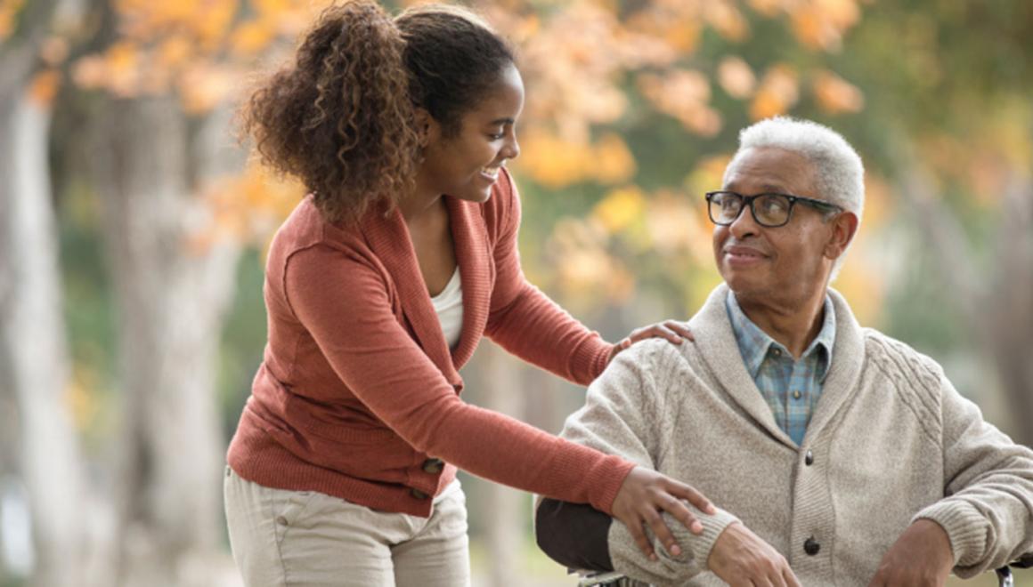 A student showing compassion to an older adult in a wheelchair