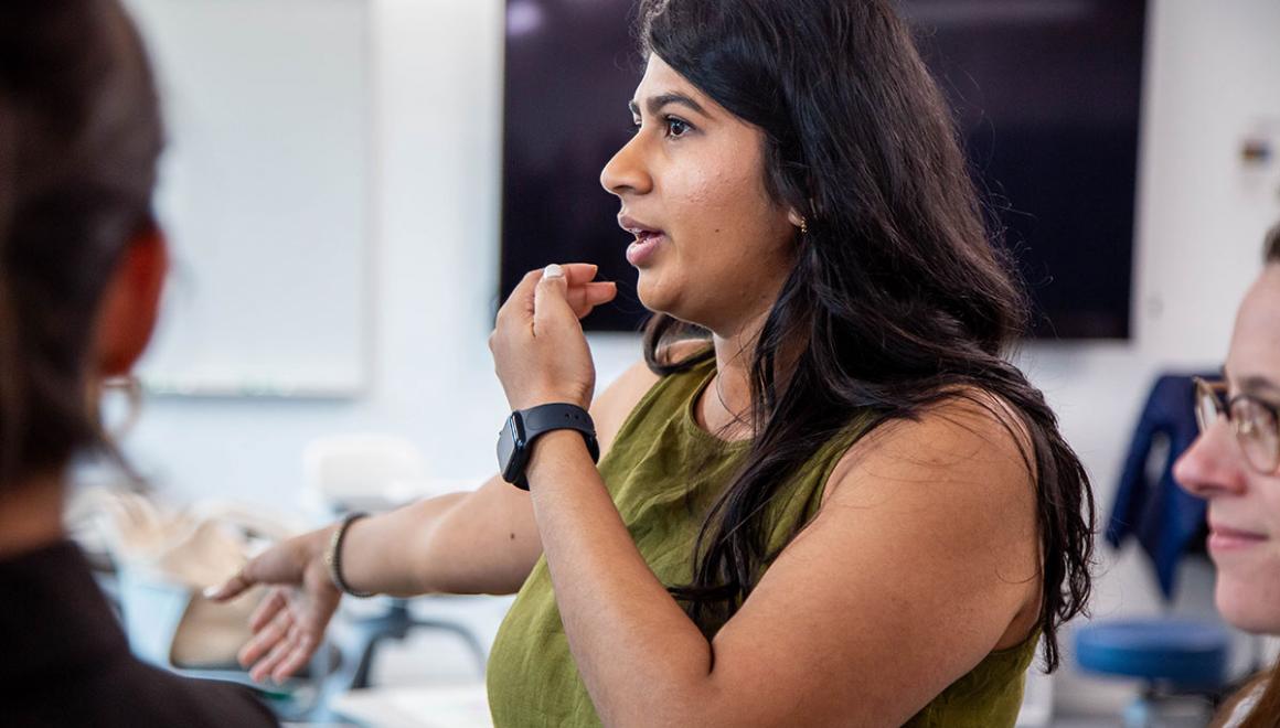 Simmons students standing and gesturing during a classroom session