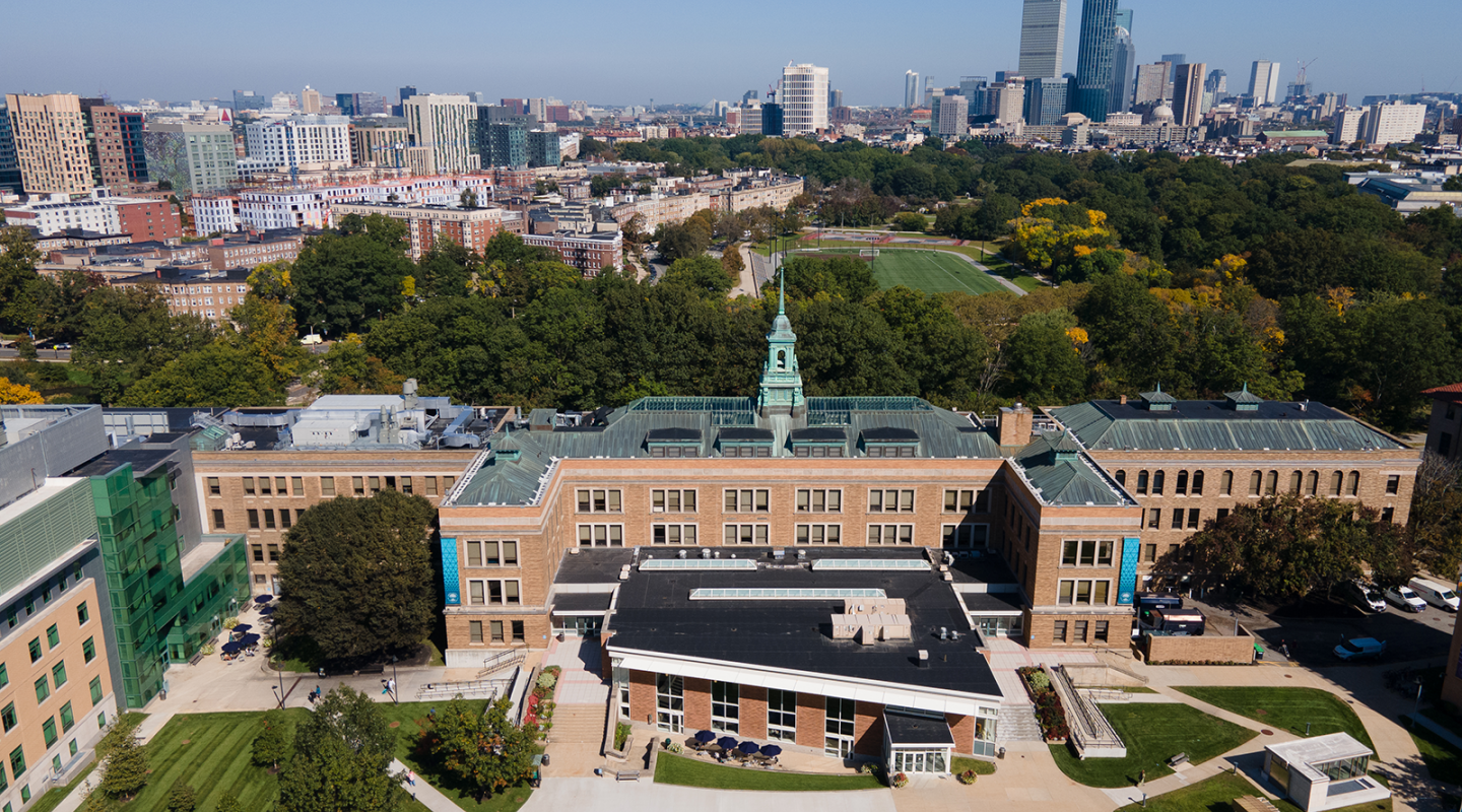 An aerial photo of the Main College Building on the Simmons campus, with the city of Boston in the background