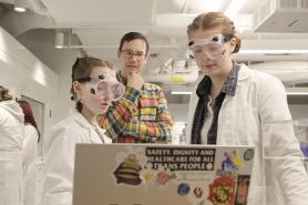 Two students studying data on a laptop in a science lab