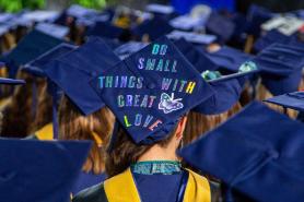 Commencement cap with the message "Do small things with great love"