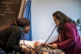 Two nursing students perform an exam on a nursing mannequin