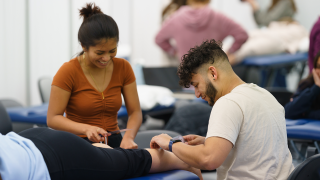 Two graduate students doing hands-on training in the Physical Therapy lab