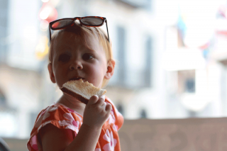 A small child eating a piece of toast.