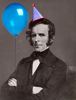 John Simmons wearing a birthday hat and holding a balloon.