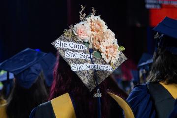 Commencement cap with the message “She came, she saw, she mastered”