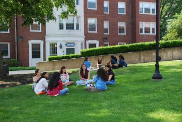 Orientation 2024 - Student sitting together in the grass of the Residence Campus