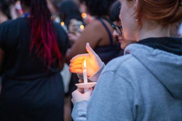 A student holds a lit candle during the candle lighting event on move-in weekend 2024