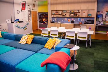 Couches, gathering tables and shelves of resources in the Simmons Multicultural Center