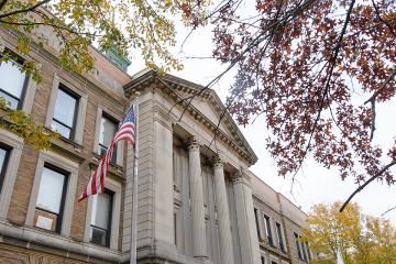 US flag in front of the Simmons University Main College Building