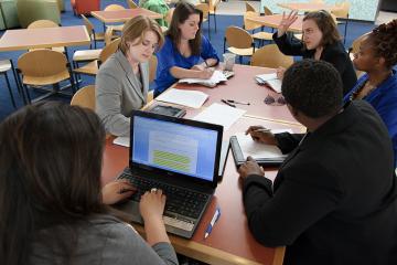 Students sitting around a table in discussion.