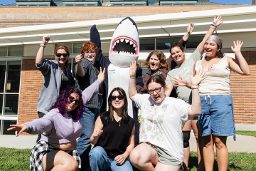 A group of orientation leaders and Stormy waving with excitement 