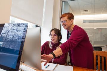 A Library and Information Science faculty member working with a student