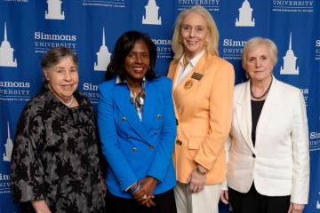 President Lynn Perry Wooten, Dean Astrid Sheil and two alums at the welcome event for the new SOM Dean.