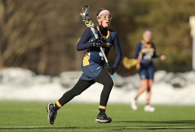 Student playing lacrosse at Daly Field