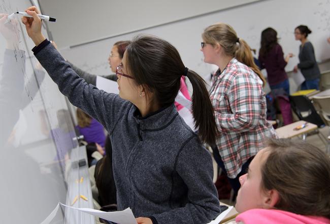 Student writing on a whiteboard