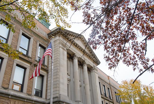 US flag in front of the Simmons University Main College Building