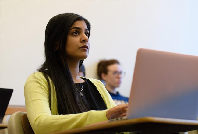 Student sitting in classroom with laptop