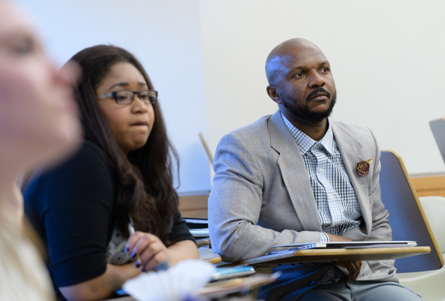 Two graduate students paying attention during a class