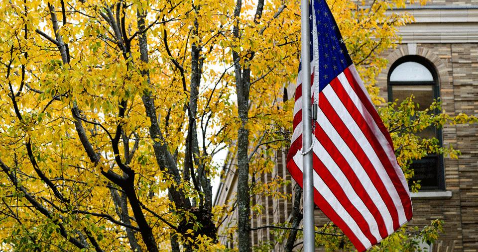 American Flag outside Simmons University in the Fall