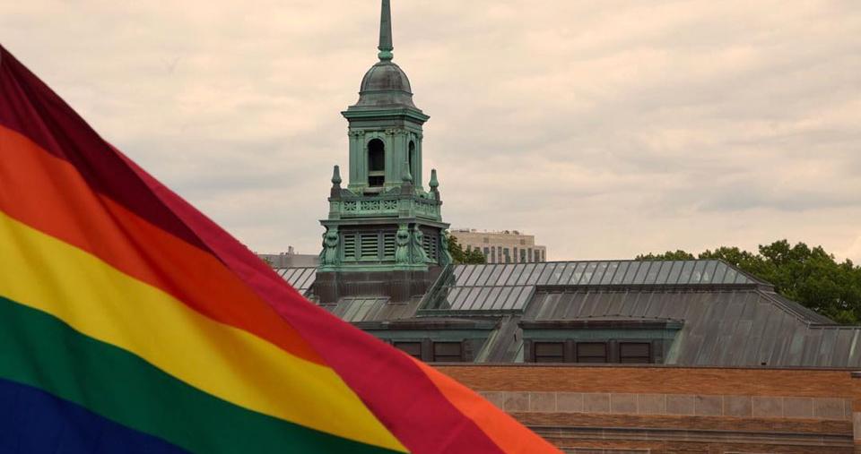 The cupola of the Main College Building on the Simmons campus with a Pride flag in the foreground