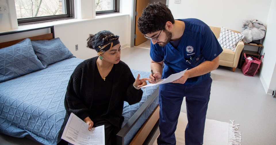 A nursing student working in a home health simulation room