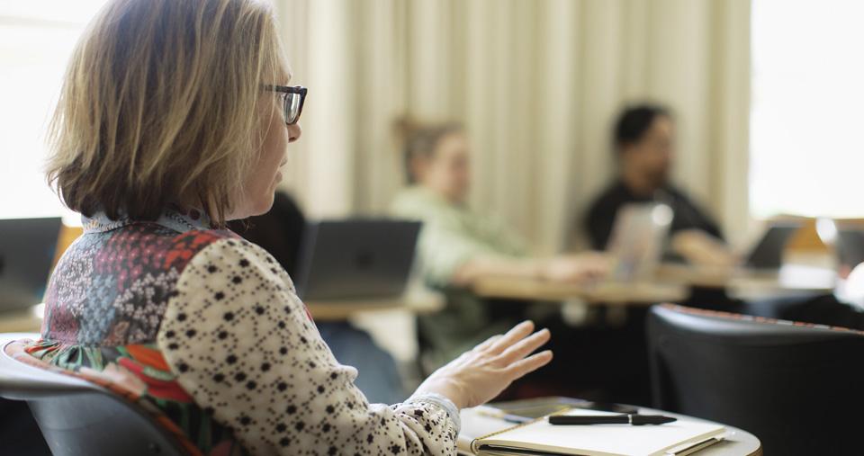 Person speaking at desk in SSW classroom