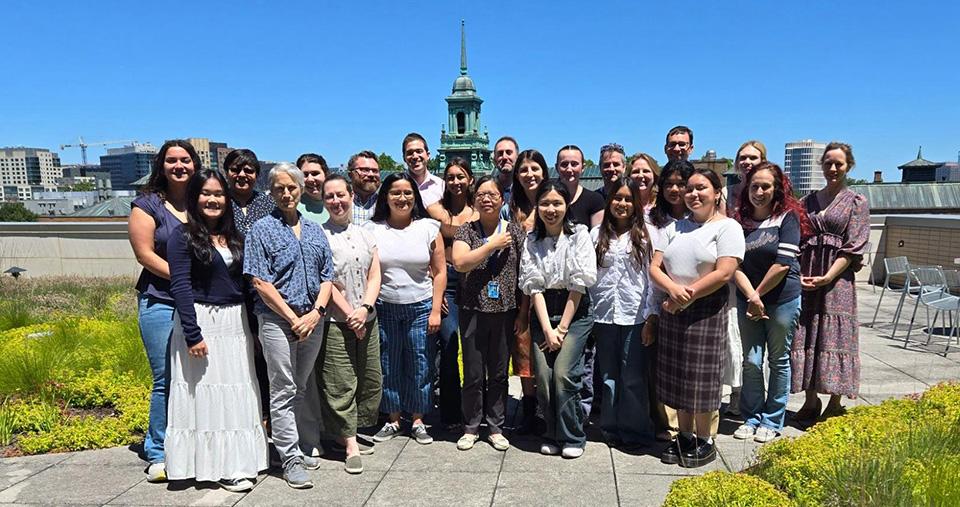 SURPASs students posing on Management Building Patio on sunny day. Simmons Cupola in background.